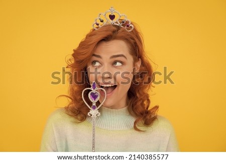 happy redhead woman in queen crown with magic wand, make wish