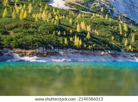 Mountains with forest and reflection on the surface of the lake. Landscape in the highlands during sunset. Photo in high resolution.