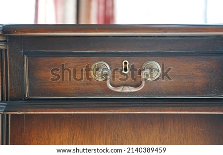 Wooden desk drawer with handle and keyhole                                Royalty-Free Stock Photo #2140389459