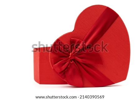Red heart-shaped gift box with a red ribbon on white background. Happy Valentine's Day. Anniversary. 