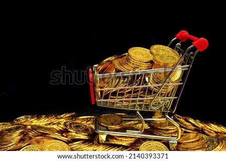 Golden coin in the shopping cart on a stacking gold coins at black background