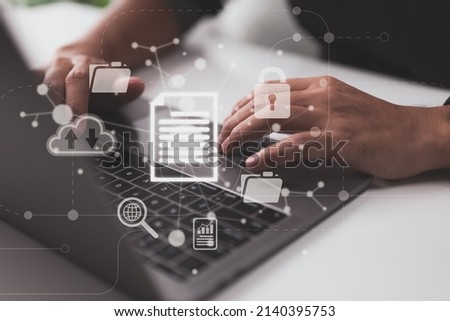 An IT professional in the workplace is configuring a document management system (DMS) on a laptop. Archiving, finding, and management software for business files and data. Royalty-Free Stock Photo #2140395753