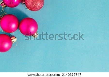 Pink Christmas Light Bulbs. Christmas Background from Pink Balls, Ornament on a Turquoise Background. Happy New Year and Merry Christmas.