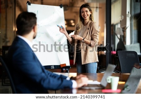 Businesswoman present her idea to working team. Young beautiful woman presenting businessplan. Royalty-Free Stock Photo #2140399741