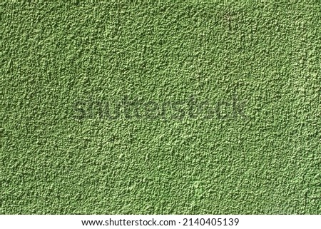 Painted wall with rough texture closeup. Green plaster with brushed texture, house wall, copy space