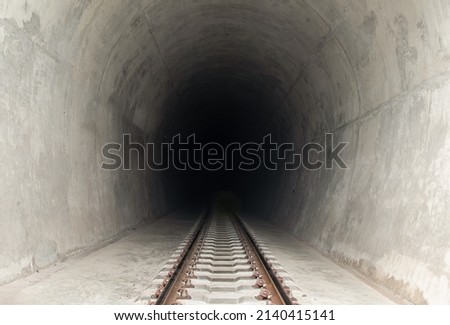 Railway track leading lines into the dark train tunnel entrance. Traveling by train, Space for text, Selective focus.