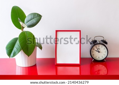 Red frame on a white background with a flower and a clock. Design. Mock-up. Copy space