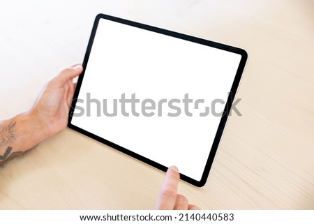 Close up photo of man using tablet computer, empty white screen mockup