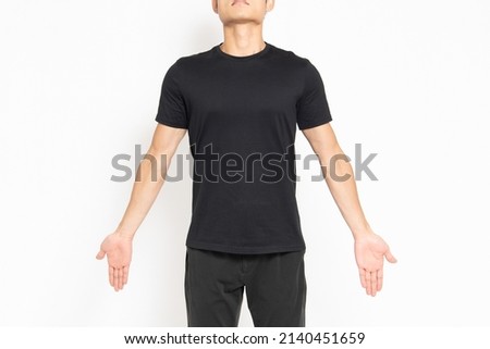 A man wearing a black T-shirt standing in front of a white background and taking a deep breath Royalty-Free Stock Photo #2140451659