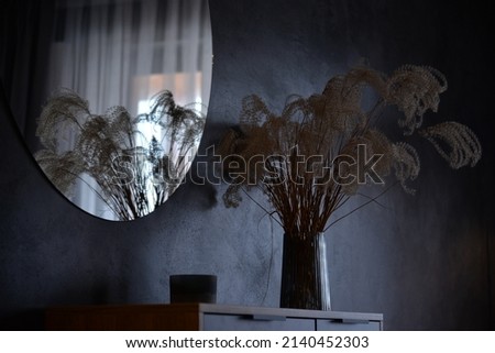 vase with dried flowers in a dark room