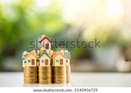 Home model put on the stack gold coin on sunlight in the public park, Loan for real estate or saving money for buy a new house to family in the future concept. Royalty-Free Stock Photo #2140456729