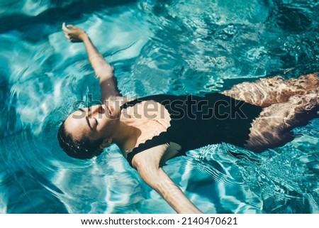 Woman relaxing in the swimming pool. Royalty-Free Stock Photo #2140470621