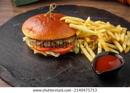 burger and fries on dark board, bun without sesame