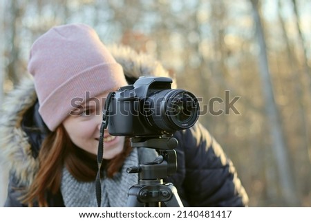 The girl is a photographer, looking at the camera display. Photographing. Photographer's Day