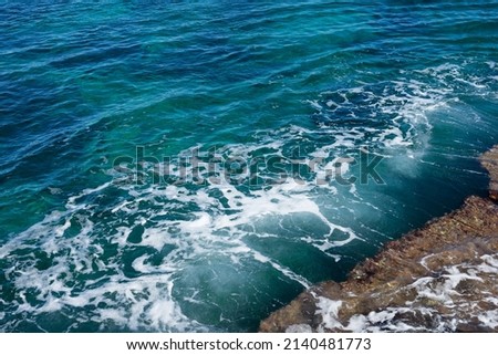 smooth waves and sea foam on the Mediterranean coast in Spain flowing water background

