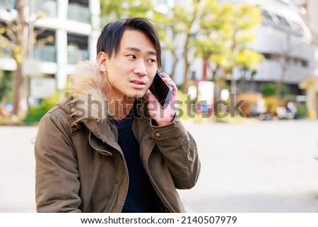 Handsome Japanese man calling in the park