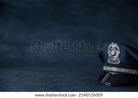 A navy blue police hat cap in front of a navy blue background with copy space. Royalty-Free Stock Photo #2140526009