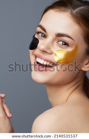 beautiful woman black and gold patches on the face close-up Lifestyle