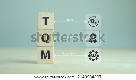 Total quality management (TQM) concept, TQM on wooden cubes with symbols on smart background, copy space. Management approach to long-term success through customer satisfaction and sustainability. Royalty-Free Stock Photo #2140534807