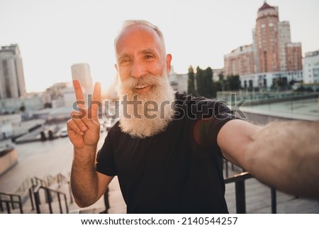 Photo of cheerful positive friendly retired trainer influencer take selfie show v-sign wear t-shirt urban town outdoors