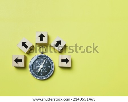Top view magnetic compass with multiple arrow icons on wooden cubes. Royalty-Free Stock Photo #2140551463