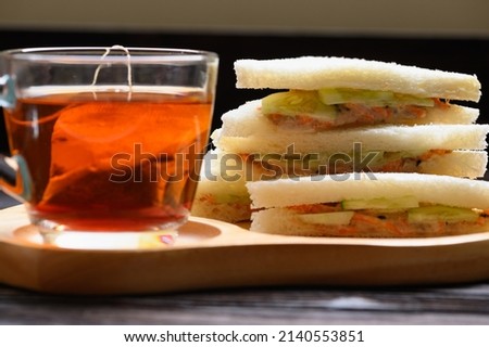 Hot Tea with Tuna Sandwich on wooden plate wood background