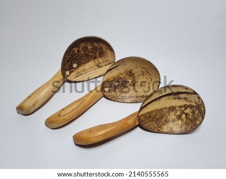 Kitchen utensils made of wood and brown coconut shells, namely a large rice spoon