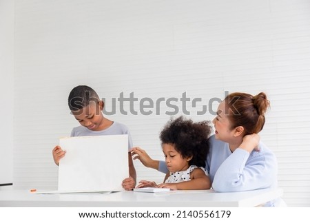 Grandmother and grandchildren playing cheerfully in living room, Children and grandparents drawing together pictures, Boy showing his painting