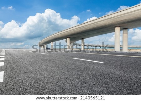 Asphalt highway and bridge under blue sky Royalty-Free Stock Photo #2140565121