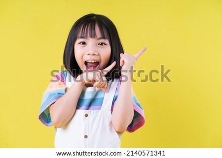 Portrait of Asian child on yellow background Royalty-Free Stock Photo #2140571341