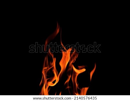 Close up burning flames on black background for graphic design or wallpaper. Red and yellow, heat energy igniting fuel during night. Abstract shaped fire used for cooking.