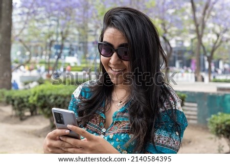 Young woman using her cellphone in a park
