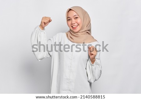 Excited Asian Muslim woman celebrating victory isolated over white background Royalty-Free Stock Photo #2140588815