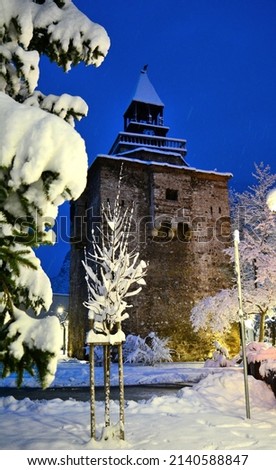 Winter landscape of the city of Vratsa, Bulgaria. Winter blue hour picture of stone clock tower of covered with snow city.