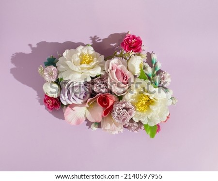 A floral composition made of colorful flowers. Purple, pink, white and yellow tones on purple background. Minimalist spring concept. Neat floral pattern. Copy space. Flat lay. Royalty-Free Stock Photo #2140597955