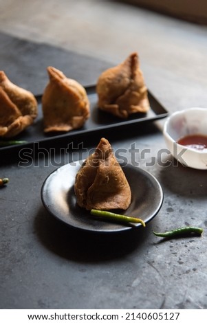 Popular Indian snack item samosa on a black dish. Close up, selective focus. 
