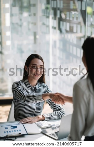 Young asian business people shaking hands in the office. Finishing successful meeting. Royalty-Free Stock Photo #2140605717