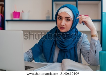 Muslim student in hijab learning at home desk. Confident Muslim business woman using a laptop in the workplace. Female student doing online research.