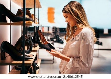 Portrait of beautiful young woman shopping new shoes in store. People shopping concept. Royalty-Free Stock Photo #2140613545