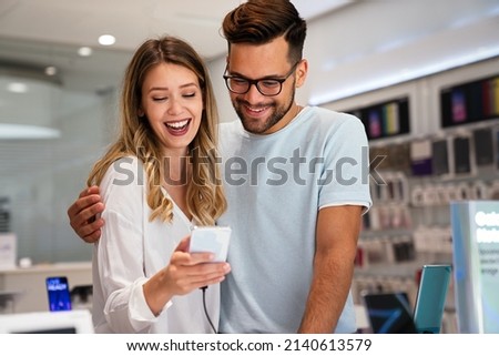 Happy young people shopping new mobile phone in a store. People technology device new concept Royalty-Free Stock Photo #2140613579