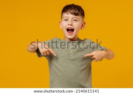 Little small smiling happy boy 6-7 years old in green casual t-shirt point in index finger on himself isolated on plain yellow background studio portrait. Mother's Day love family lifestyle concept Royalty-Free Stock Photo #2140615141