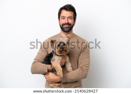 Man holding a yorkshire isolated on white background smiling a lot