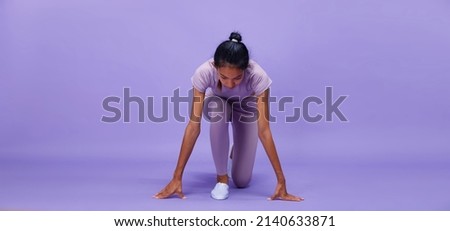 Full length of Asian slim tanned skin Fitness woman hands touch ground floor ready to start to run to goal, purple background, concept Woman Can Do athlete in Very Peri color block mood tone