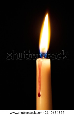 One candle burns in the dark. The concept of loneliness and self-belief. Prayers to the Lord. Vertical photo. Macro photo.