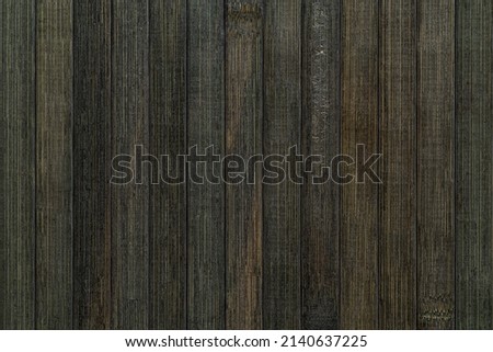 Macro texture of vertical lacquered bamboo wood planks with striped pattern. Background of greenish black bamboo boards surface. Dark element for interior design. Full frame. Top view. Royalty-Free Stock Photo #2140637225