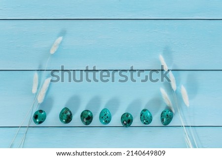 blue eggs on a blue wooden table. Geometry. minimal concept. Top view. An Easter card with place for the text.