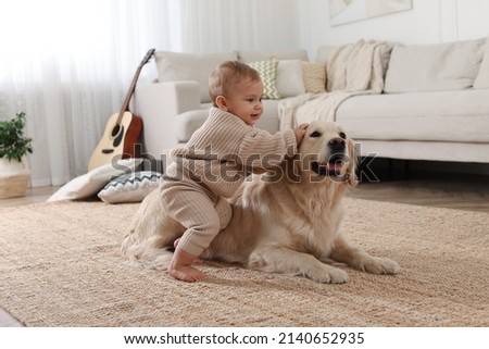 Cute little baby with adorable dog on floor at home Royalty-Free Stock Photo #2140652935