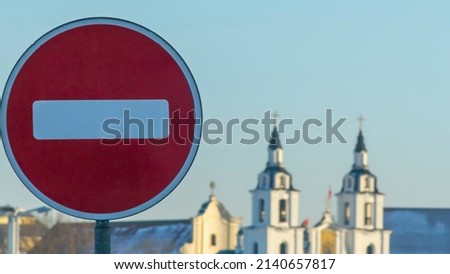 No Entry road sign on old orthodox church background. Winter. The road is closed red round sign. White brick in red circle road sign.