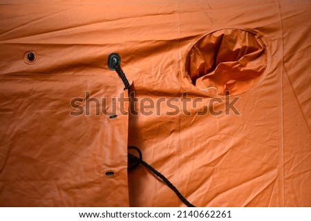 Detail photo of a window from a refugee orange tent 