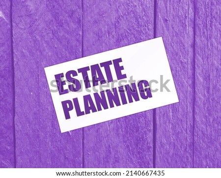 Estate Planning text, inscription words on card on wooden table. Business with real estate concept.
